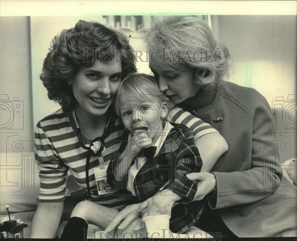 1985, Michael Troche gets hug from nurse Kristi Kirk &amp; his mom, Judy - Historic Images