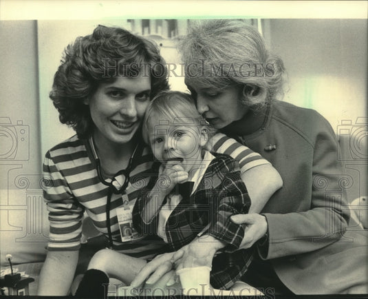 1985, Michael Troche gets hug from nurse Kristi Kirk & his mom, Judy - Historic Images