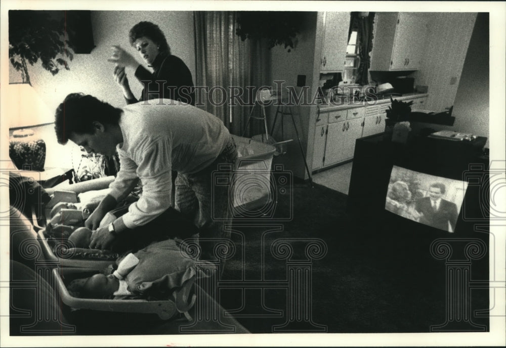 1990, Lori and Randall feeding their triplets in their home - Historic Images