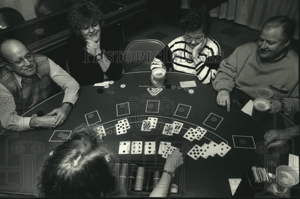1990 Audra Kerith dealer, players at blackjack table, raising money. - Historic Images