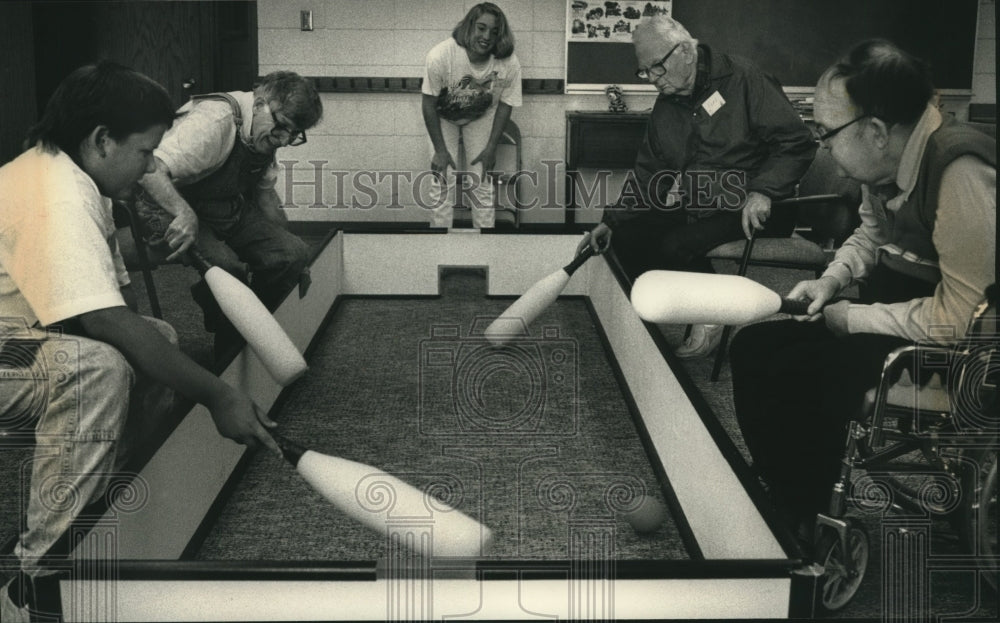 1992, Old and young playing floor hockey, Trinity Church Care Center. - Historic Images