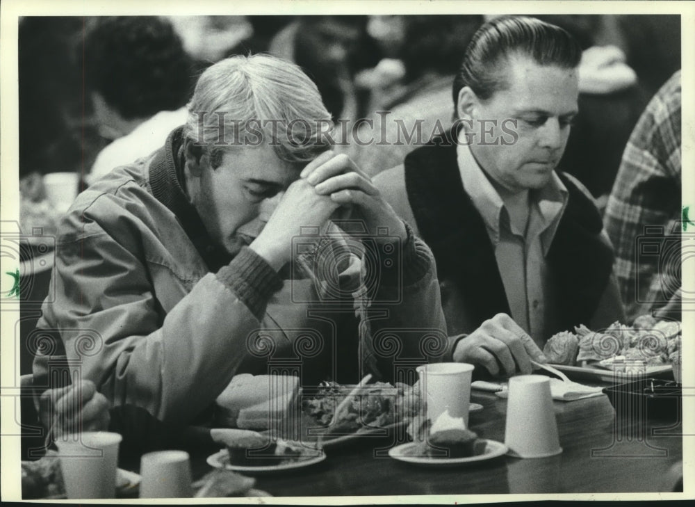 1982 A man prays at St. Benedict the Moor&#39;s Thanksgiving Day meal - Historic Images