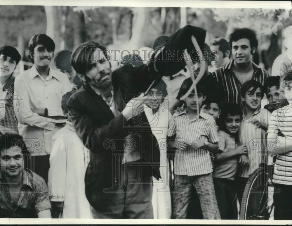 1974, A magician watched by men and boys doing bag trick, Syria. - Historic Images