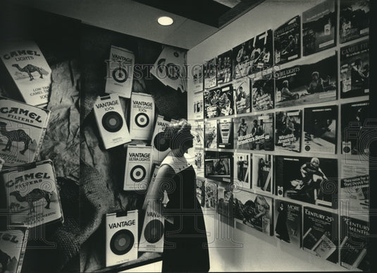 1986 Press Photo Woman looks over advertising display, RJ Reynolds factory - Historic Images