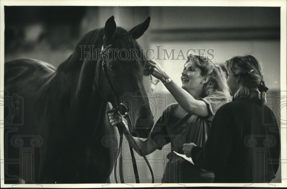 1991 Judy Zellmer places a ribbon on her mare Olympia for winning - Historic Images