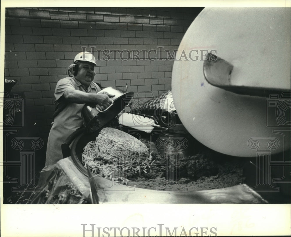 1980, Usinger worker Joe Kernats dumps ground meat into machine - Historic Images