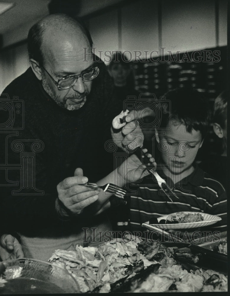 1992 Press Photo Warren Schmidt helps Michael Fickau at Thanksgiving dinner - Historic Images
