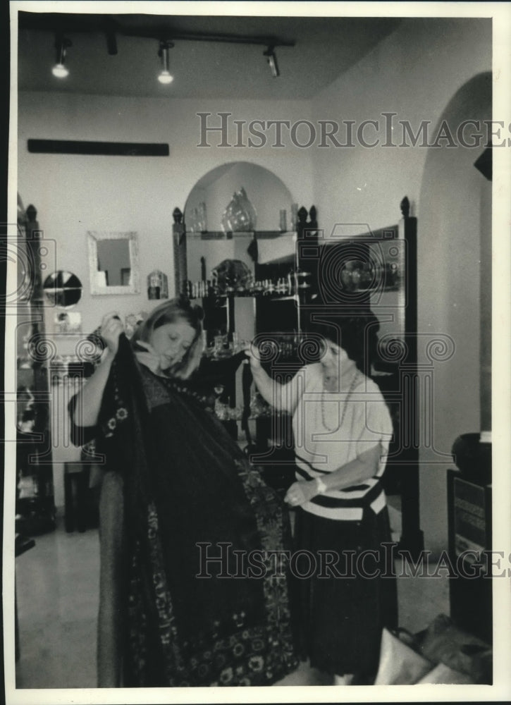 1990 Press Photo Shopkeeper Al Aydi Helps Customer With Dress in Amman, Jordan - Historic Images