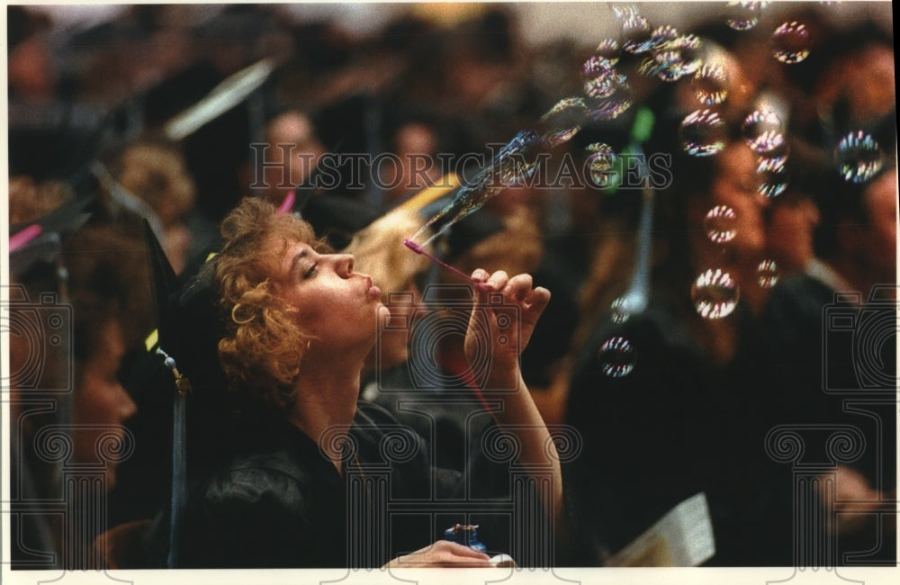 1994 Press Photo Pamela Howitt blows bubbles with students at graduation, UWM. - Historic Images