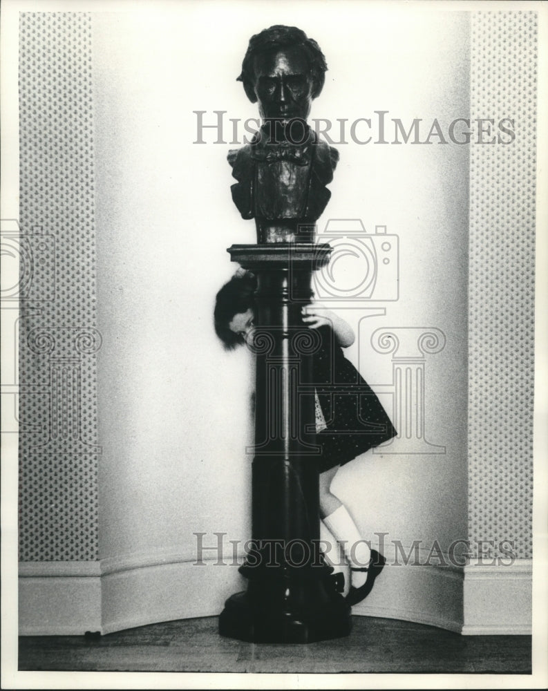 1960 Press Photo Cynthia Nelson playing around a bust of President Lincoln- Historic Images