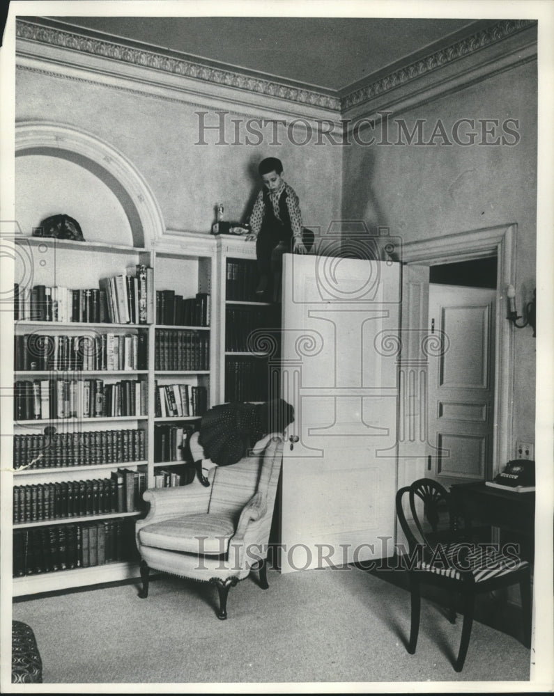 1960, Gaylord Nelson and family, child climbs atop bookshelves - Historic Images