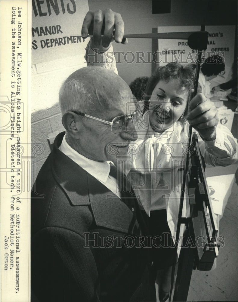 1985, Alicia Pierce measures Lee Johnson height, Senior Health Fest - Historic Images