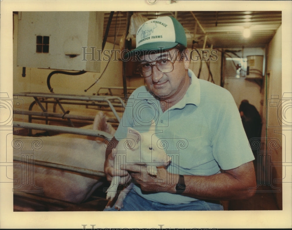 1990 National Pork Board President Hillman Schroeder and a baby pig - Historic Images