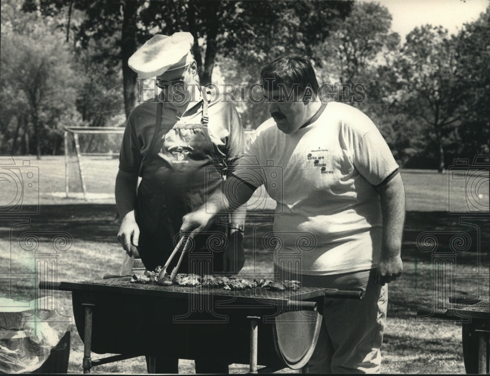 1988 Press Photo David F. Schulz and Dean Adams Inspect Steaks At Golf Course - Historic Images