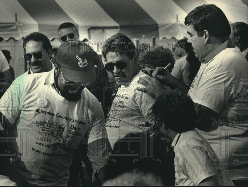1988 Press Photo David Schulz autographing shirts of people in line, Milwaukee. - Historic Images