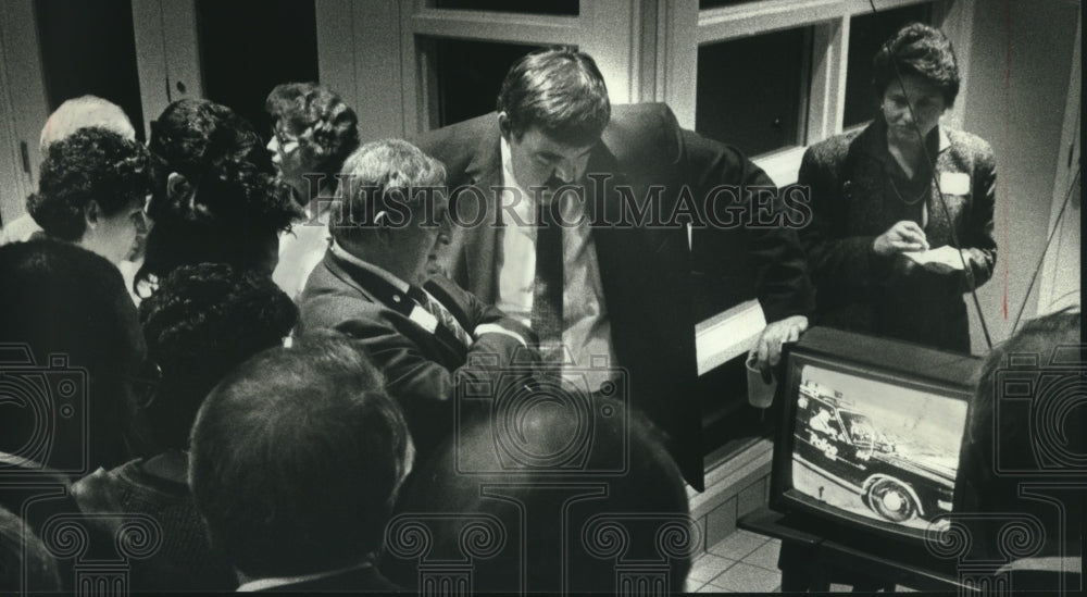 1989 David Schulz sees NBC news broadcast with others on Milwaukee. - Historic Images