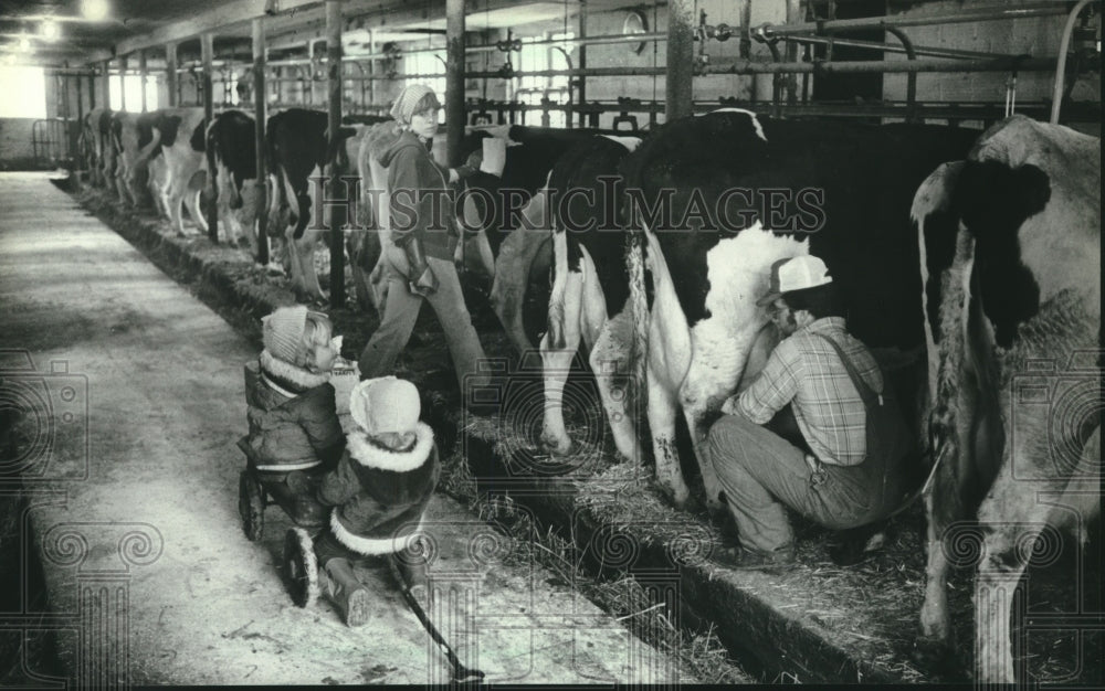 1982, Children Watch As Suzanne &amp; Paul Chip Milk Cows On Their Farm - Historic Images