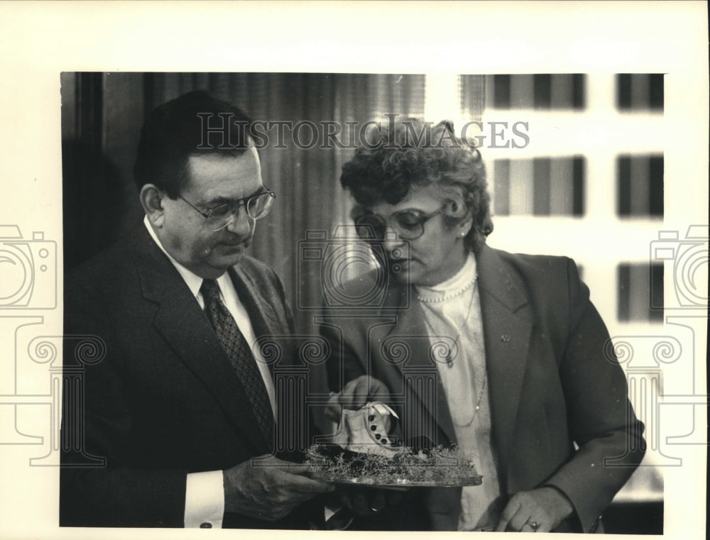 1988, Donald J. Schuenke Receives Baby Shoes From Carol Zaffrann - Historic Images