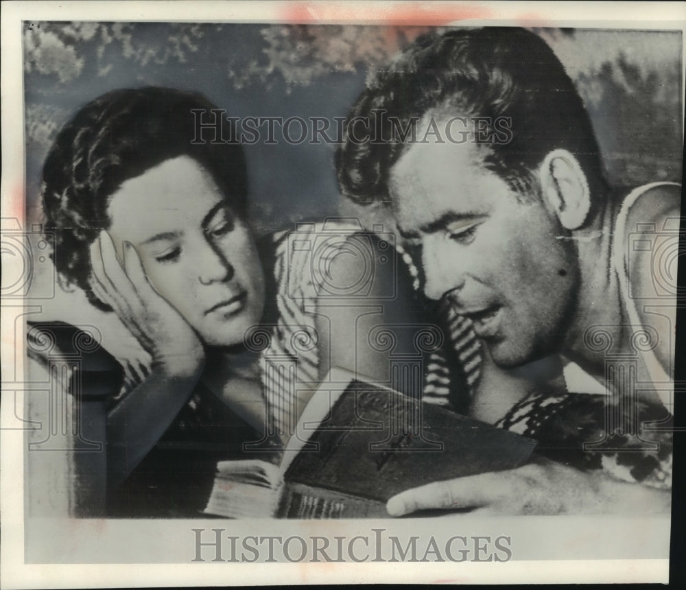 1961, Major Titov reads a book with wife before his space flight. - Historic Images