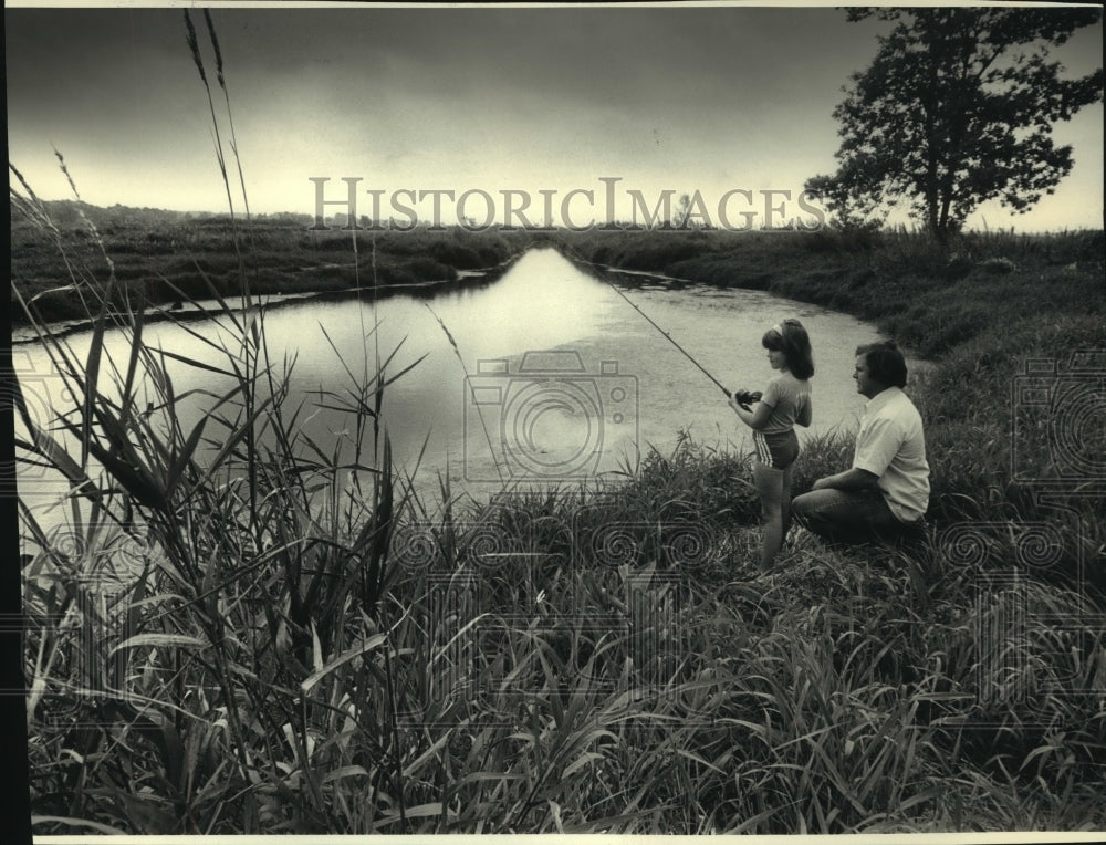 1986, Dale Anderson watches daughter April fish in Theresa Marsh - Historic Images