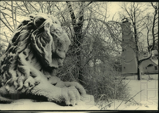 1987 Press Photo Falling snow accented a lion statute in Lake Park, Milwaukee - Historic Images