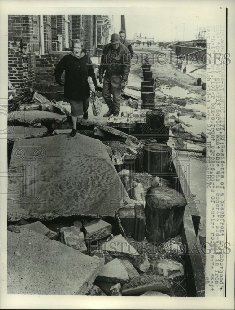 1962 Press Photo Atlantic City residents walk on storm-damaged sidewalk gingerly - Historic Images
