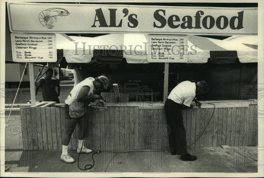 1988, Workers put finishing details on Al's Seafood Summerfest booth - Historic Images