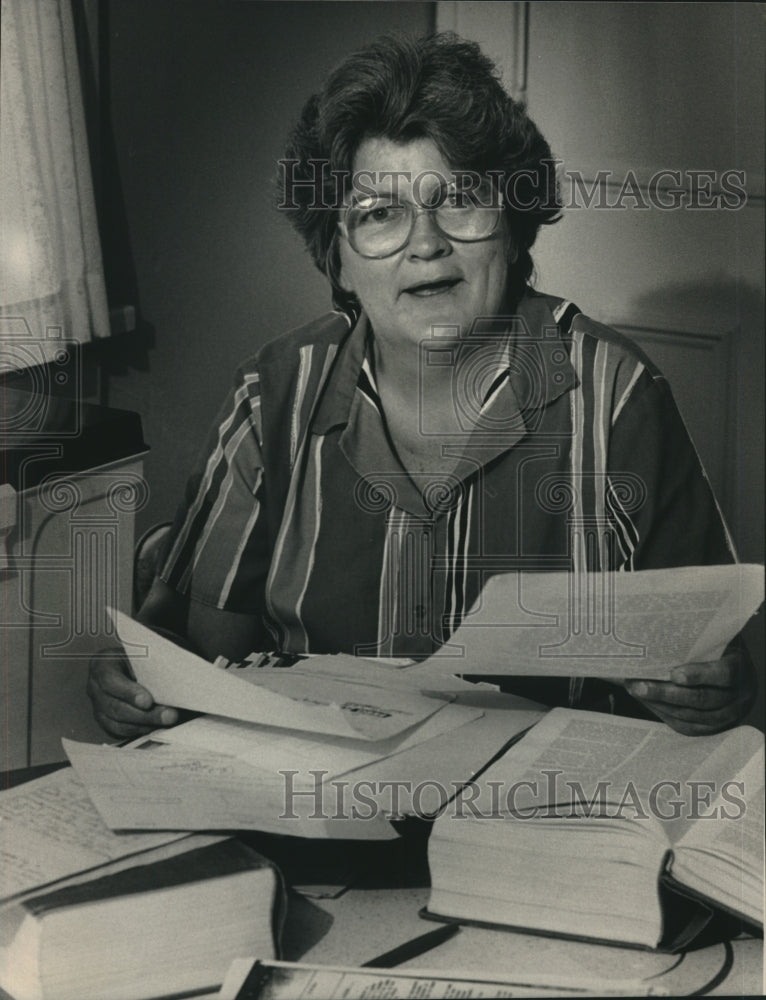 1986 Press Photo Judy Van searches through stacks of documents for her child - Historic Images