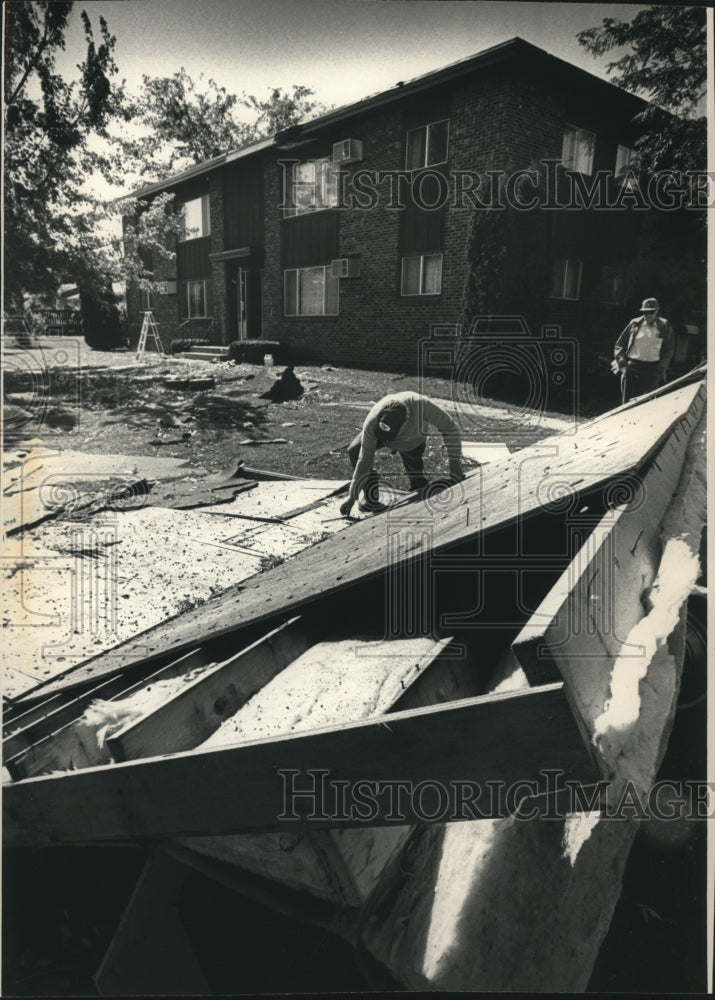 1992, Wisconsin apartment manager Herbert Humphrey inspects roof - Historic Images