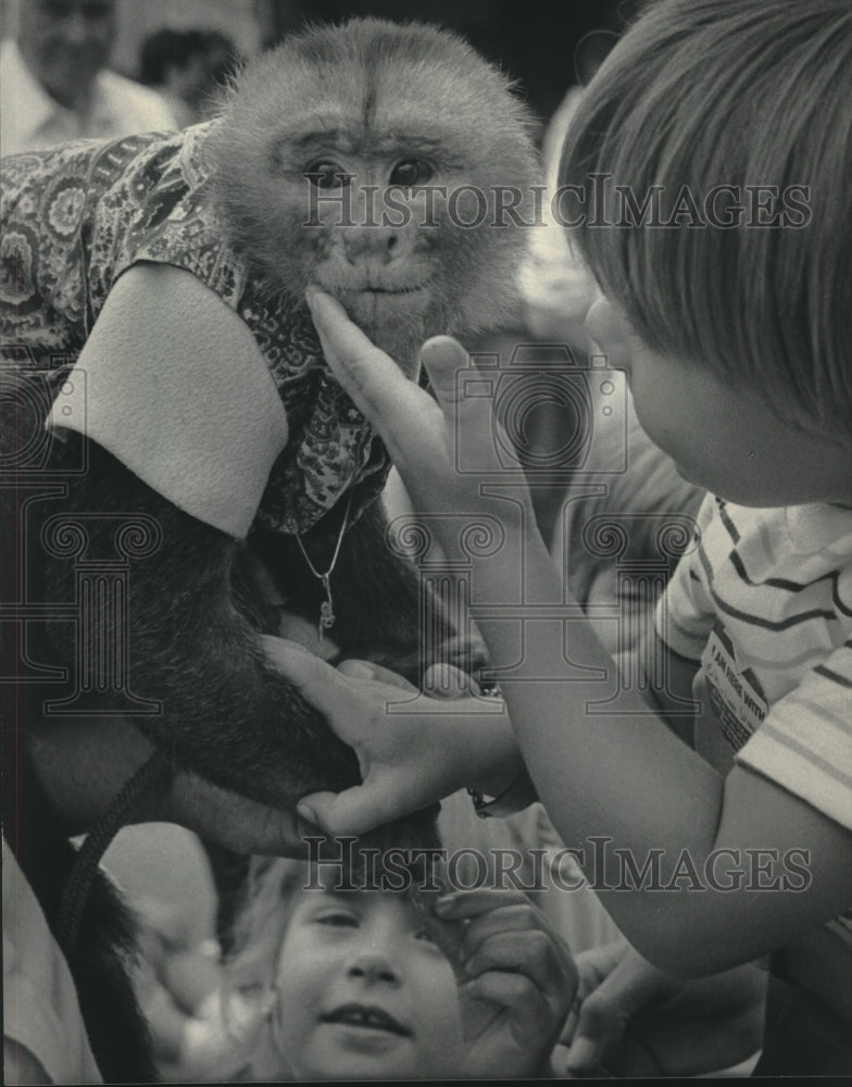 1985 Adam Monk, a monkey being petted by young boy at Summerfest - Historic Images