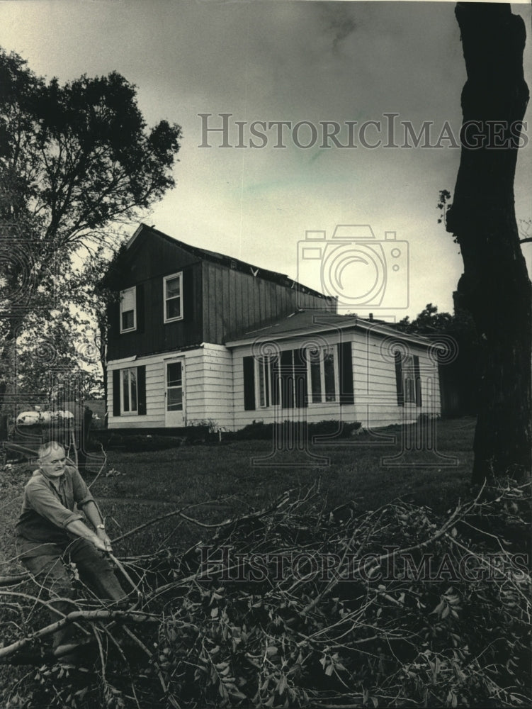 1986 Press Photo Duncan McIntyre Moving Branches Felled in Storm in Wisconsin - Historic Images