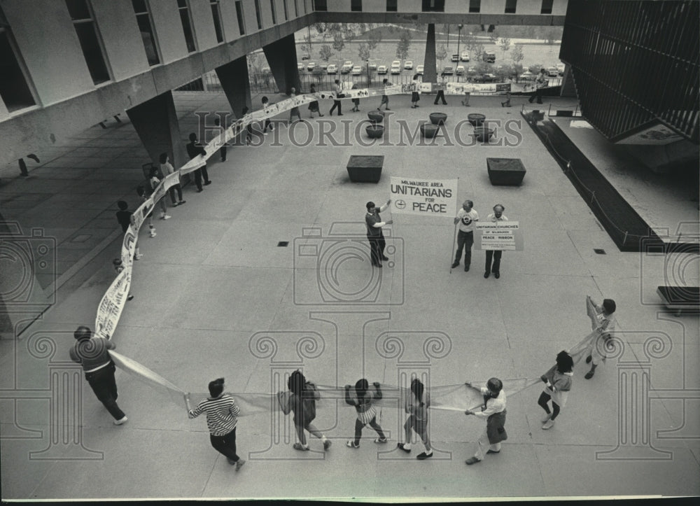 1985 Milwaukee Unitarians carry peace ribbon at War Memorial Center - Historic Images