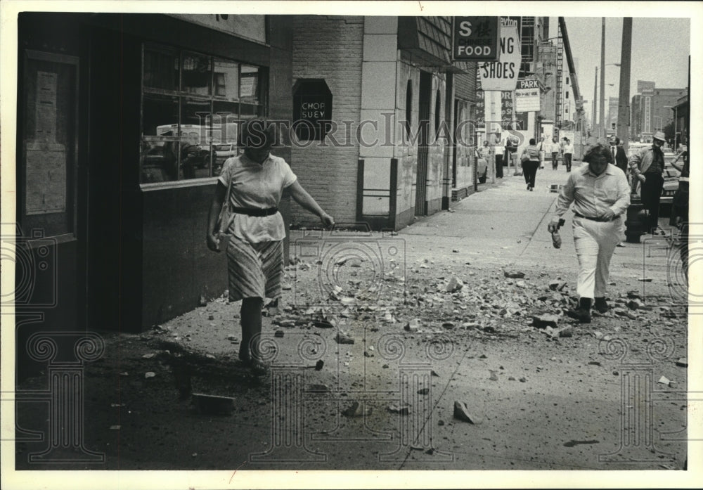 1979, Pedestrians step around debris that fell 10 stories, Milwaukee. - Historic Images