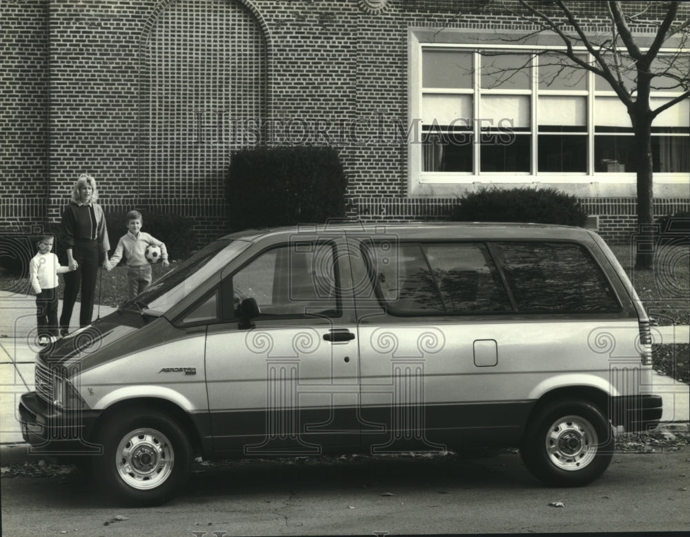 1985 The Ford Aerostar parked at school as family looks on. - Historic Images