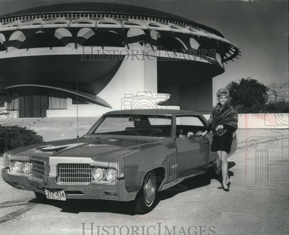 1968 Press Photo Fur Wearing model next to Oldsmobile Luxury 98 four door sedan - Historic Images