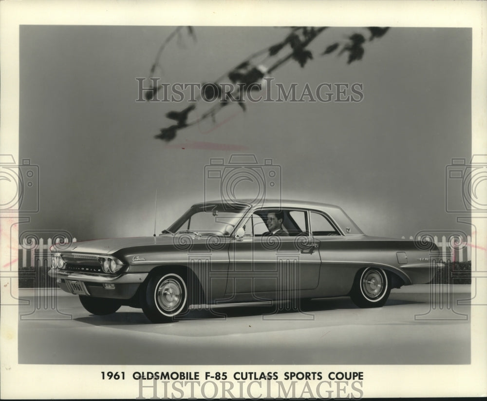 1961 Press Photo Man sitting in F-85 Oldsmobile, Cutlass Sports Coupe - Historic Images