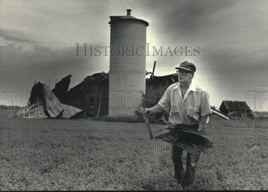 1985 Press Photo Eugene Dibbles Picks Up Debris from Barn Destroyed in Storm - Historic Images