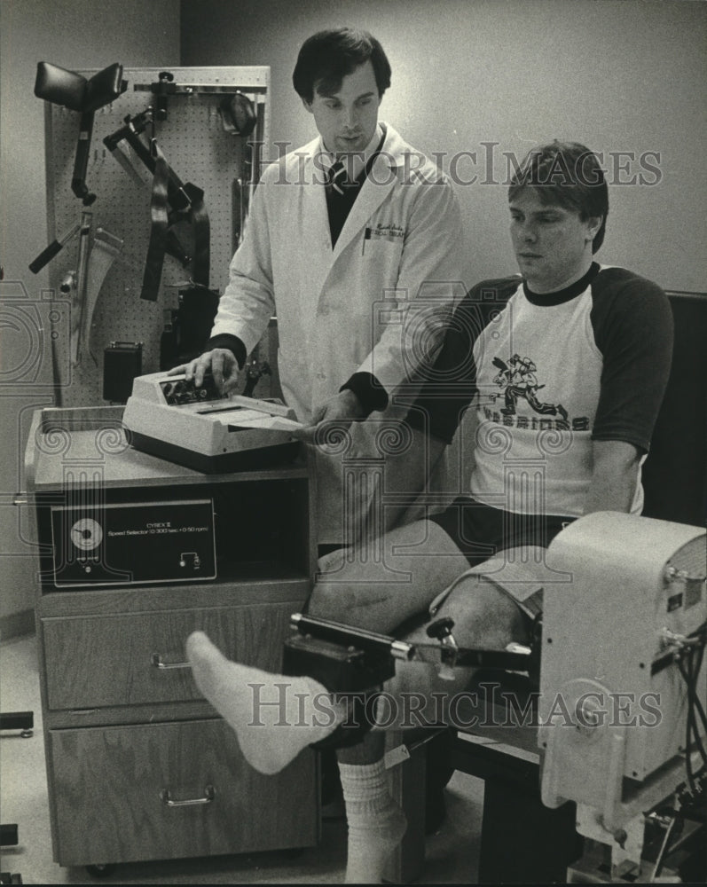 1984, Bob Seeds, Steve Eberhardt , using machine to check leg muscles - Historic Images