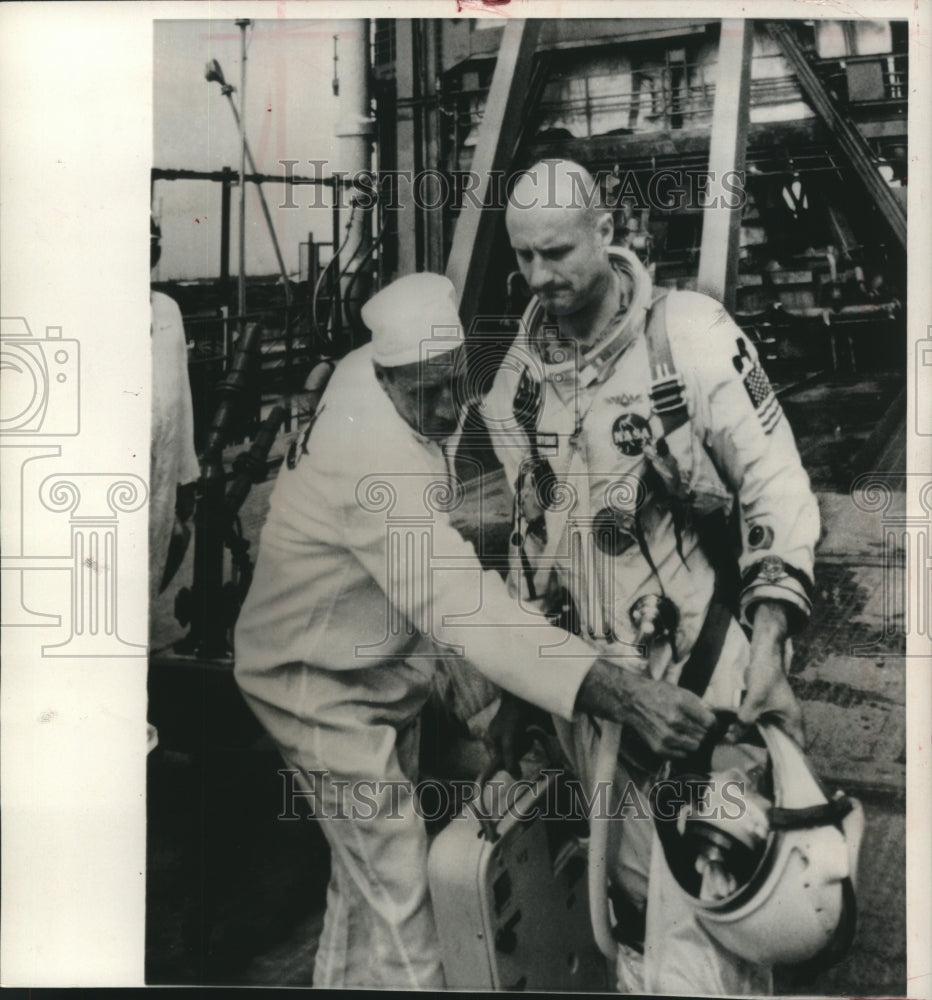 1965, Astronaut Thomas Stafford hands his helmet to technician - Historic Images