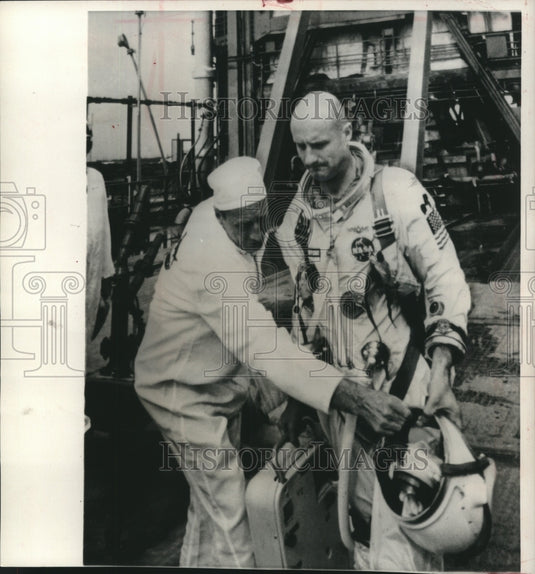 1965, Astronaut Thomas Stafford hands his helmet to technician - Historic Images
