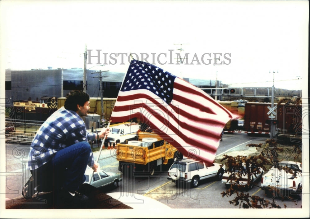 1992 Press Photo Steve Berger Hoists New Flag Above Berger Templeton Inn, Sussex - Historic Images