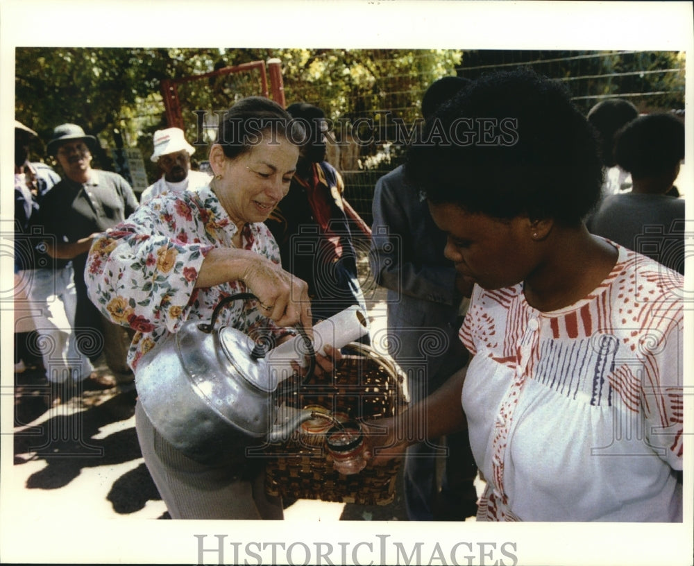 1994, South African voters are served water as they wait in line - Historic Images