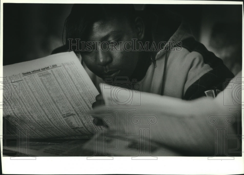 1994, Sadie Lee at 68th Street High School in Milwaukee reads stocks - Historic Images