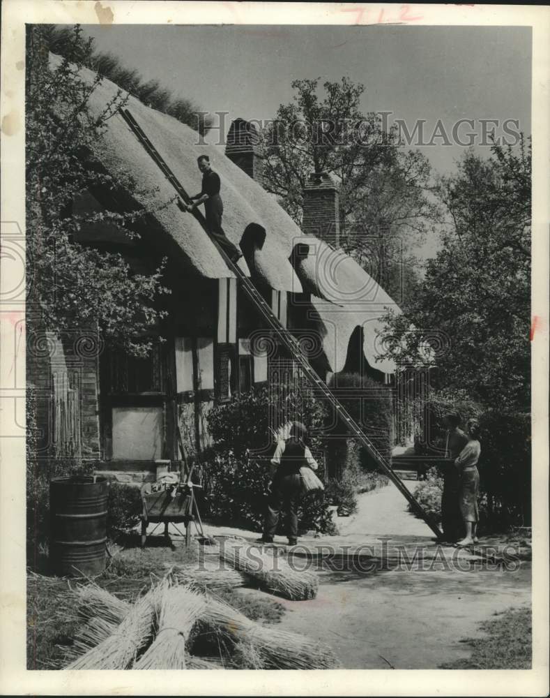 1957 Press Photo Men work on Shakespeare and Anne Hathaway's cottage, England. - Historic Images