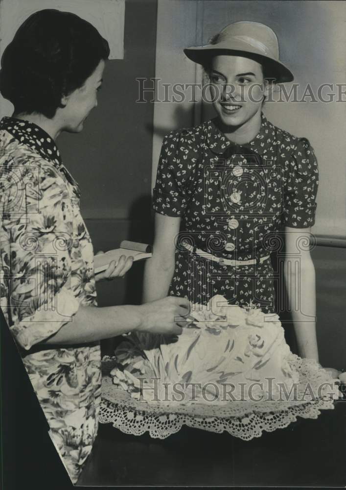 1938, Jeanne Johnson buying cake for her upcoming wedding, Milwaukee. - Historic Images