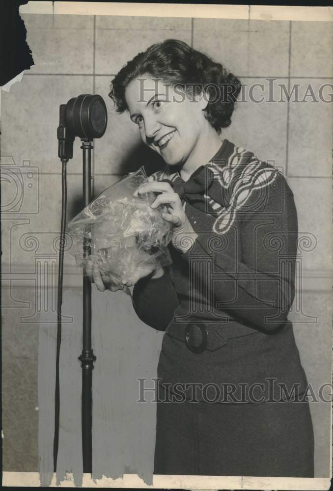 1935 Evelyn Williams creates fire sounds in mike by using props. - Historic Images