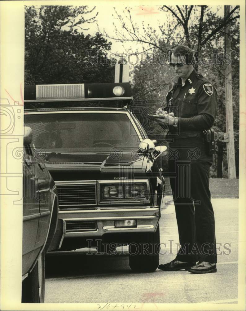 1980 Press Photo Jerry Leppla checked car during patrol Beloit, Wisconsin - Historic Images