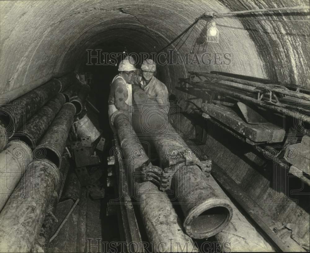 1980 Press Photo Buford and Halbur load pipes on train in tunnel, Milwaukee - Historic Images