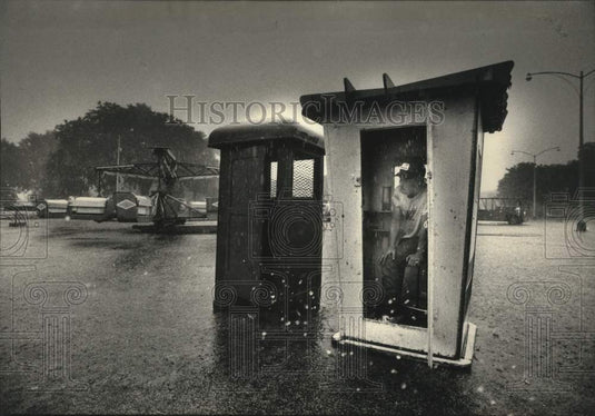 1992 Press Photo Dan Holland seeks shelter from hailstorm at Carnival Milwaukee - Historic Images