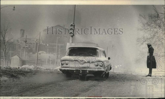 1974 Police officer directing traffic in snowstorm, Milwaukee - Historic Images